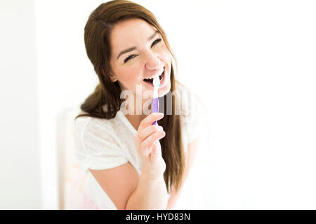 Donna che sfrega i denti e sorride Foto Stock