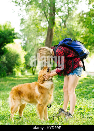 Giovane donna che gioca con Golden Retriever Foto Stock