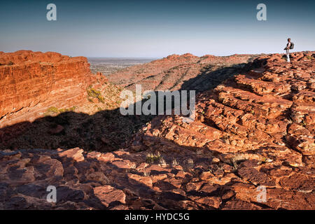 Femmina singolo escursionista con fotocamera alla sommità del Kings Canyon nella luce del mattino con cielo chiaro Foto Stock