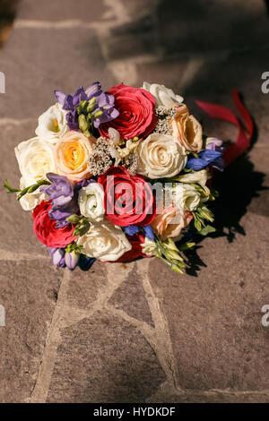 Colorate Bouquet nozze con nastro rosa giacenti su lastre di pietra Foto Stock