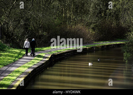 Couple walking near Trent and Mersey canal enjoying sunny spring afternoon in Stoke on Trent,Staffordshire,UK.Shot from behind.31 March,2017. Foto Stock