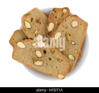 Vista dall'alto di diversi strati di mandorla con pistacchio pane fresco in un piccolo recipiente isolato su uno sfondo bianco. Foto Stock