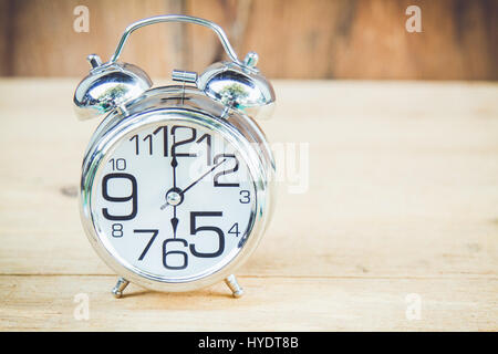 Mostra orologio 6 am o pm su uno sfondo di legno con copia spazio. Foto Stock