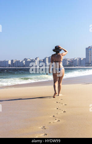 Donna chiedendo sulla spiaggia di Copacabana in una mattina di sole e di Rio de Janeiro, Brasile Foto Stock