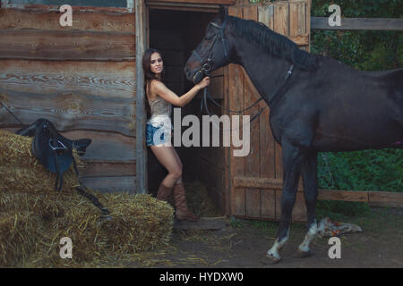 Bella donna e cavallo in una fattoria nella campagna. Foto Stock