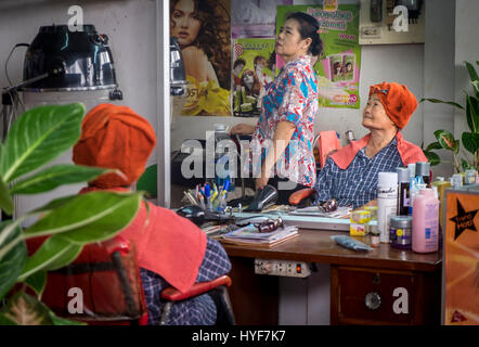 MAE KLONG - TAHILAND - CIRCA NEL SETTEMBRE 2014: tailandese donne in un parrucchiere intorno al Maeklong mercato ferroviario Foto Stock