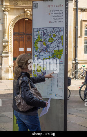 Signora tourist guardando mappa di Cambridge Center per i luoghi di interesse Foto Stock