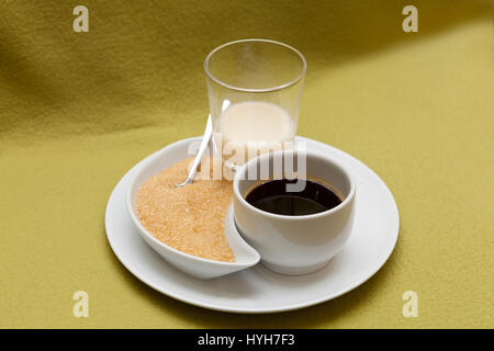 Nero caffè, latte e zucchero di canna su una piastra Foto Stock