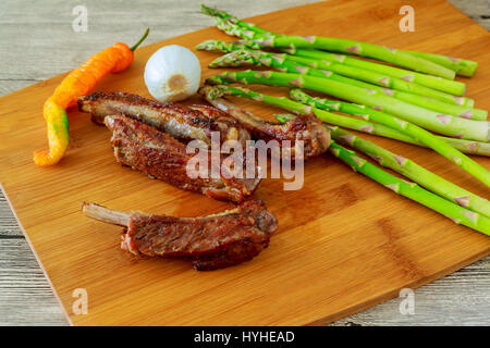 Delizioso BBQ Ribs con pane tostato, cole slaw e una piccante salsa barbecue costolette di maiale asparagi pepe Foto Stock