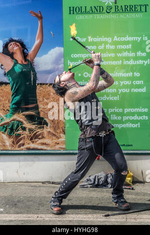 L'artista di strada eseguendo il fuoco mangiare su una strada di Whitby. Foto Stock