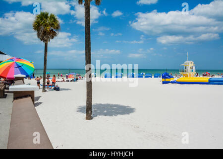 Vista di coloro che godono di sabbia bianca e acque turchesi di Clearwater Beach, FL, con il numero 5 la torre bagnino e blu e bianco e cananas umbría Foto Stock