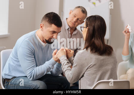 Concentrato di persona maschile ascoltando con attenzione il suo collega Foto Stock