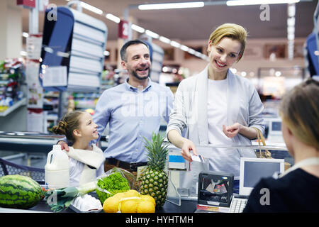 Famiglia dal supermercato checkout Foto Stock