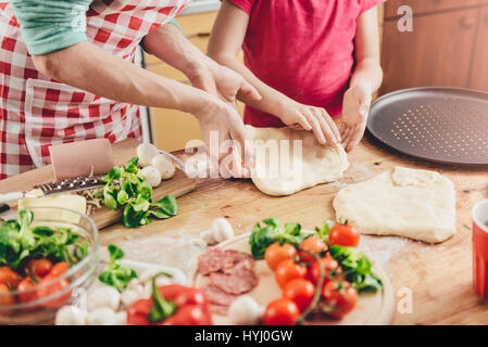 Madre e figlia preparare la pizza in cucina Foto Stock