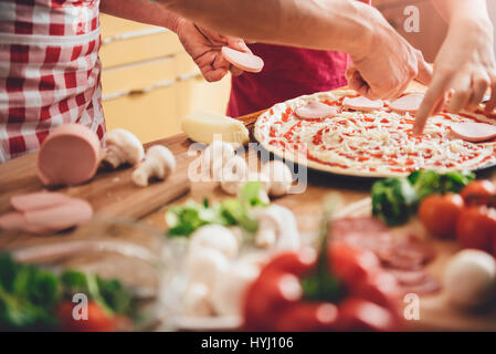 Madre e figlia preparare la pizza in cucina Foto Stock