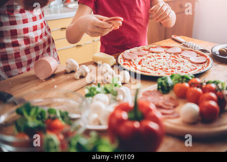 Madre e figlia preparare la pizza in cucina Foto Stock