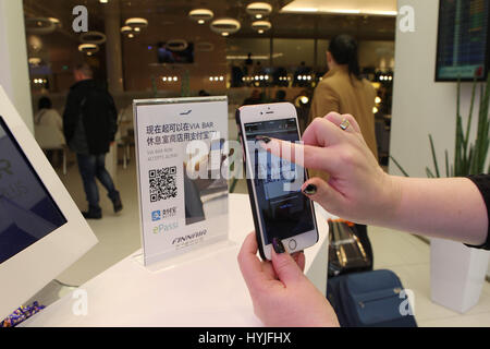 (170405) -- PECHINO, 5 aprile 2017 (Xinhua) -- Un cliente utilizza la Cina del Alipay presso l'aeroporto di Helsinki, Finlandia, 28 marzo 2017. Compagnia aerea finlandese Finnair ha aperto un diretto itinerario di volo tra Helsinki e a Pechino nel 1988, che è stato il primo in Europa per la Cina. Il progetto è stato un pioniere e di molte principali compagnie aeree europee seguirono. Quasi 30 anni più tardi, Finnair rimane fra le cinque principali compagnie aeree europee operanti in Cina. Vola una trentina di voli diretti a sei destinazioni cinesi a settimana in media. Nel gennaio 2017, esso ha avviato un progetto pilota di installazione Alipay sul volo da Shanghai Foto Stock