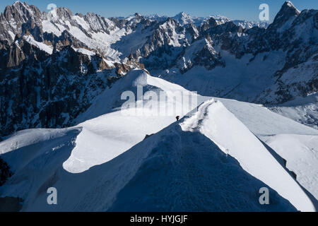 Scalatore ascendente tratto finale su arete crinale che conduce fino a Aiguille du Midi in inizio inverno condizioni soleggiate Foto Stock