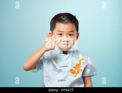 Little Boy dandovi pollice in alto Foto Stock