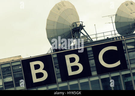 Il logo della BBC con antenne paraboliche per la ricezione satellitare Foto Stock