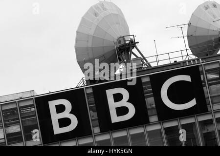 Il logo della BBC con antenne paraboliche per la ricezione satellitare Foto Stock