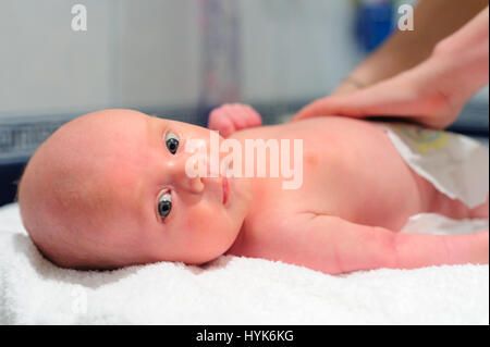 La mamma mette un pannolino sul baby Foto Stock