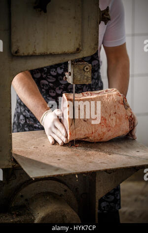 Macellaio è il taglio di carne a fette sulla segatrice a nastro presso lo store Foto Stock