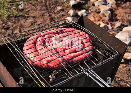 Travel kielbasa cottura. Salsiccia cruda per barbecue Foto Stock