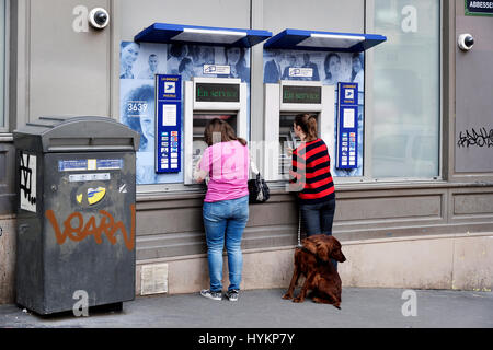 Due persone che utilizzano bancomat esterni di La Banque Postale a Montmartre, Parigi Foto Stock