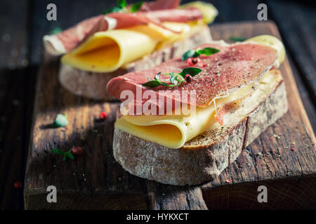 Deliziosa un pezzo di pane con prosciutto e formaggio Foto Stock