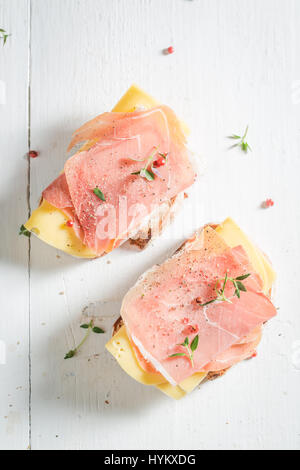 Fresco di un pezzo di pane con prosciutto e formaggio Foto Stock