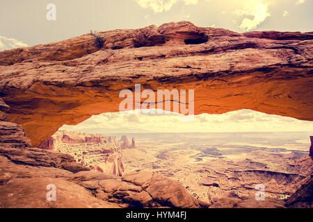 Visualizzazione classica del famoso Mesa Arch, simbolo del sud-ovest americano, illuminata a scenic golden. La luce del mattino al sorgere del sole su una bella giornata in estate Foto Stock