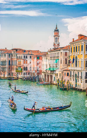 Vista verticale delle tradizionali gondole sul Canal Grande con il campanile storico di Santi Apostoli la Chiesa in background in una giornata di sole in Venezia Foto Stock