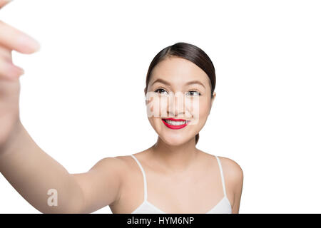 Bella donna asiatica con retro trucco prendendo foto selfie isolati su sfondo bianco. Foto Stock