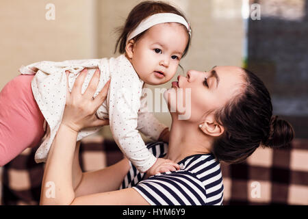 Giovane donna felice azienda Baby girl in mani. Foto Stock