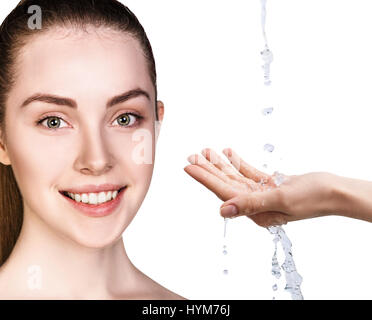 Donna faccia e versando acqua in mano. Foto Stock