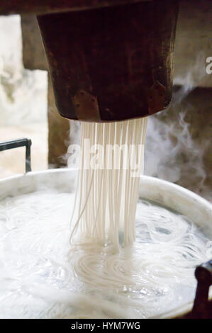 Tagliatelle tradizionali rendendo procedura su una macchina vintage Foto Stock