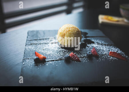 Grigliata di gelato in noce di cocco con salsa di pietra nera piastra. Cibo asiatico dello sfondo. Concetto di mangiare. Il ristorante posto con un tavolo di legno. Spazio copia fo Foto Stock