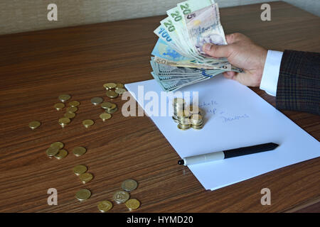 Braccio della persona d'affari nella camicia di contenimento valute di carta, euro, dollari e Lire con penna e moneta sulla carta nota Foto Stock