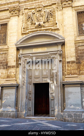 La porta principale di San Francesco di Assisi chiesa con lo stemma del gran maestro Gregorio Carafa che ornano la facciata, Valletta, Malta Foto Stock