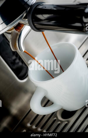 Pompa tradizionale macchina da caffè espresso versando shot nella tazza bianca Foto Stock