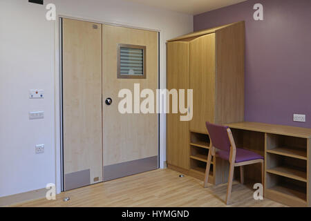 Interno di una camera da letto in un nuovo sicuro, residenziale unità psichiatrica. Mostra le porte dotate di anti-legatura le maniglie della porta e bloccare il raccordo. Foto Stock