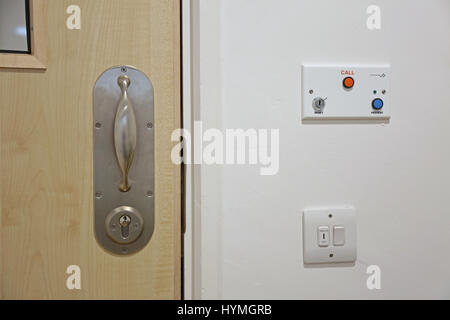 Chiusura di una porta in un'unità psichiatrica sicura e residenziale. Mostra la maniglia della porta e il montaggio della serratura antilegatura, progettati per evitare il rischio di strangolamento Foto Stock
