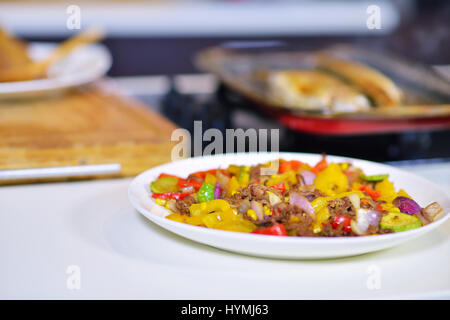 Salsicce alla griglia con verdure grigliate sul tavolo da cucina Foto Stock