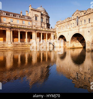 Pulteney Bridge e porticato, bagno, Inghilterra, su una luminosa mattina di primavera, che si riflette nel fiume Avon. Il ponte è stato progettato da Robert Adam e comp Foto Stock