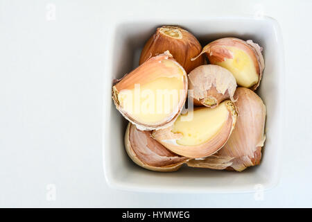 Primo piano di una ciotola di bianco rosa di spicchi di aglio Foto Stock