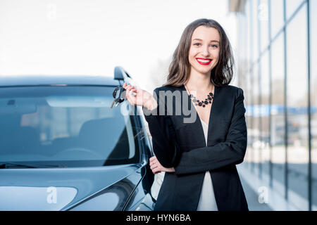 Donna con i tasti vicino alla macchina Foto Stock