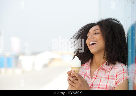 Close up ritratto di una giovane e bella donna sorridente e tenendo cono gelato all'aperto Foto Stock