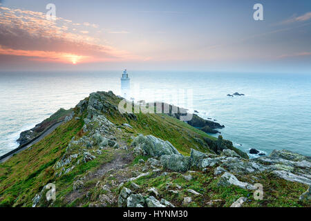 Alba sopra il faro presso il punto di partenza del Devon Coast Foto Stock