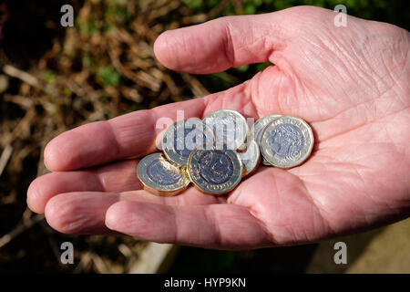 Pound monete in mano Foto Stock